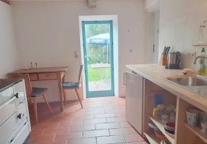 a kitchen with a sink and a table and a door at Ferienwohnung Terwey in Geisenhausen +8 photos