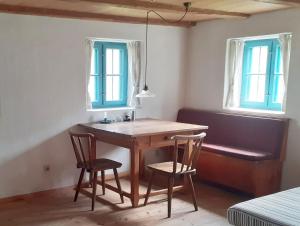 a table and two chairs in a room with two windows at Ferienwohnung Terwey in Geisenhausen