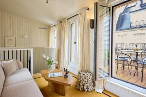 a living room with a couch and a table at Hôtel Noucha in Paris