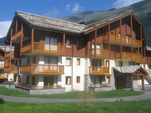 ein großes Gebäude mit Holzbalkonen darauf in der Unterkunft Résidence Les Alpages de Val Cenis in Lanslebourg-Mont-Cenis