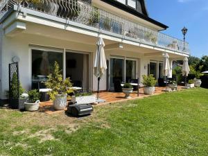 a house with a patio with umbrellas and a lawn at Ferienwohnungen Lohmann in Bullay +15 photos