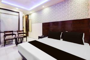 a bedroom with a bed and a table and chairs at Hotel O Priya Palace in New Delhi
