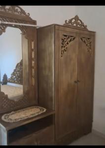 a wooden cabinet with a mirror in a room at Dar Kelesh in Kelibia