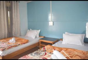 a room with two beds and a table in it at The Local Treat in Pedong