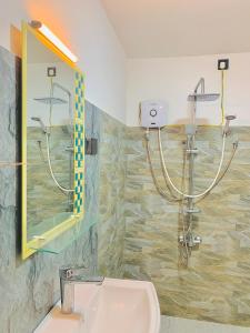 Un baño con ducha, lavabo y espejo. en Noah's Place, en Mirissa