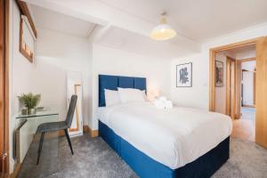 Un dormitorio con una cama grande y un escritorio. en BnBNova - 2BR Penthouse with Terrace - Heart of Holborn, en Londres