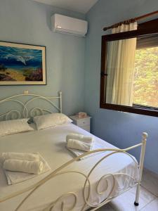 a white bed in a bedroom with a window at Seaside Dream Kallithea in Kallithea Halkidikis
