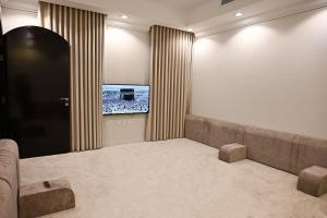 a living room with a couch and a large window at Waad Chalet in Taif