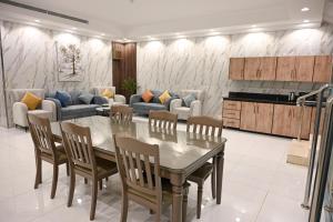 a living room with a table and chairs and a couch at Waad Chalet in Taif