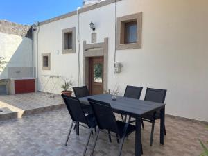 ein schwarzer Tisch und Stühle auf einer Terrasse in der Unterkunft Kamara Cottage - Traditional Stone House in Malona Village