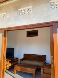 Una sala de estar con un sofá y un televisor. en Arta Villa Amed, en Amed