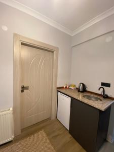 a kitchen with a sink and a white door at İngolaSuit in Çamlıhemşin