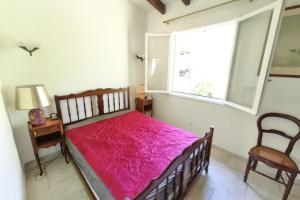 una camera da letto con un letto con una coperta rosa sopra di Ecological house with solar electricity ad Ajaccio Altre 20 foto