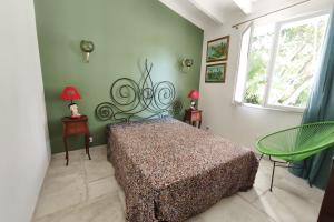 a bedroom with a bed and two tables and a window at Ecological house with solar electricity in Ajaccio +14 photos