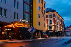 a city street with buildings and flags on the sidewalk at Original Sokos Hotel Puijonsarvi in Kuopio