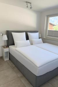 two white beds in a bedroom with a window at Apartment Eder in Waidring