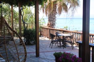a patio with a table and chairs and the beach at Seaside Dream Kallithea in Kallithea Halkidikis