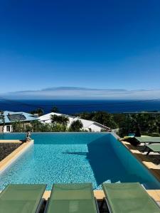 a swimming pool with a view of the ocean at La Villa Des Oliviers chambres d hôtes in Petite Île