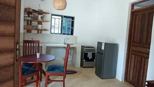 a kitchen with a table and two chairs and a refrigerator at Pahali in Bwejuu