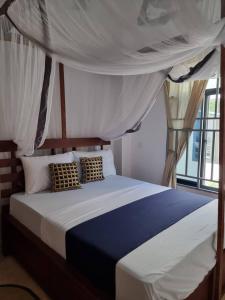 a bedroom with a bed with a canopy at Pahali in Bwejuu