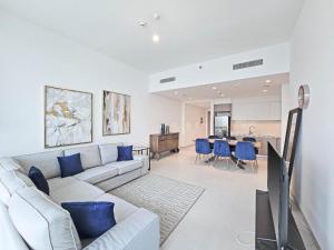 a living room with a couch and a table at Deluxe 1-Bedroom in The Grand - Waterfront and Skyline Views in Dubai