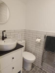 a white bathroom with a toilet and a sink at East Dart Inn in Yelverton