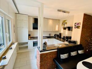 a large kitchen with white cabinets and a brick island at Wohlfühloase in Hofheim in Hofheim am Taunus