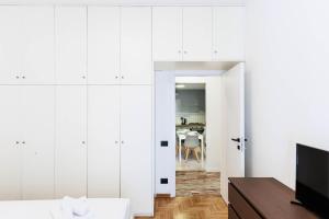 a bedroom with white cabinets and a living room at Florentine Touch - Orsini 76 in Florence