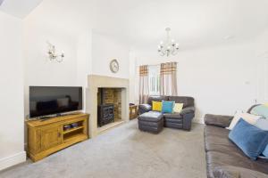 a living room with a couch and a flat screen tv at Host & Stay - Pier View in Amble