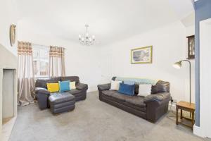a living room with two leather couches and a fireplace at Host & Stay - Pier View in Amble