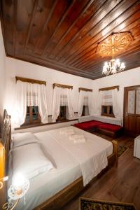 a bedroom with a large white bed with a chandelier at Traditional House & Rooms Shapllo in Gjirokastër