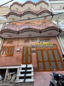 a building with orange doors and a motorcycle parked in front at G K HAVELLi in Bikaner