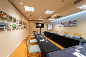 a row of tables and chairs in a room with a screen at Abba Playa Gijón in Gijón +45 photos
