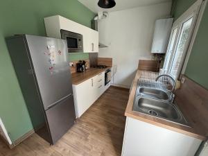 a kitchen with a stainless steel refrigerator and a sink at Maison Delavigne in Amiens