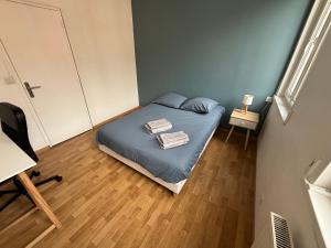a small bedroom with a bed with blue sheets at Maison Delavigne in Amiens +9 photos