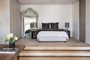 a bedroom with a large bed and a mirror at The Franklin Exclusive Suites in Johannesburg +29 photos