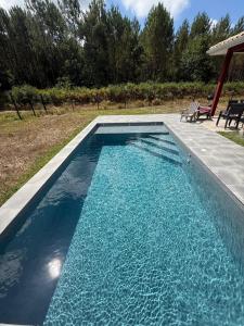 ein Swimmingpool mit blauem Wasser in einem Hof in der Unterkunft "Villa des Bourdaines" in Vielle-Saint-Girons