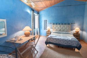 マジョーネにあるAgriturismo Borgo Spagnoliの青いベッドルーム(ベッド1台、木製テーブル付)