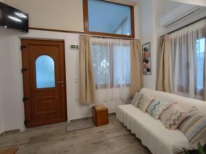 a living room with a white couch and a door at Isidora Apartments in Zagora