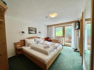 a bedroom with a bed and a large window at Apartpension Schollberg in Sankt Anton am Arlberg