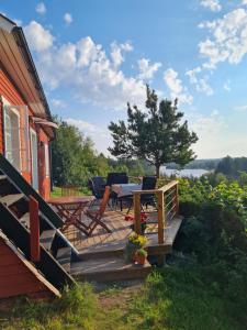 ÄlvkarlebyLillstugan的房屋内带桌椅的木制甲板