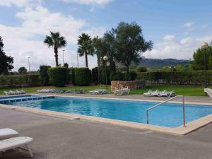 a swimming pool with lounge chairs and palm trees at Ferienwohnung Lika in Cala Bona