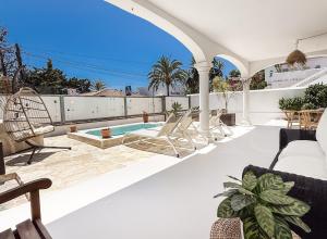 an outdoor patio with chairs and a swimming pool at Marbella House with pool and rooftop terrace REMS in Marbella