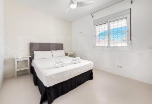 a white bedroom with a large bed and a window at Marbella House with pool and rooftop terrace REMS in Marbella +30 photos