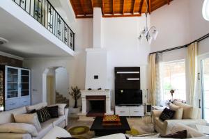 een woonkamer met witte meubels en een open haard bij Tekce Tranquil Nature Villa Yesiluzumlu N17 in Fethiye