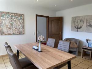 a dining room with a wooden table and chairs at Ferienwohnungen Lohmann in Bullay