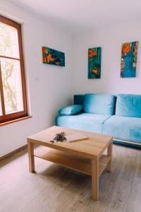 a living room with a blue couch and a coffee table at Apartma BoMa in Bovec