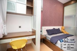 a small bedroom with a bed and a yellow chair at Jambul Residence 15 in Gua Sai