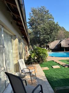 a patio with two chairs and a swimming pool at Alabaster Rest in Johannesburg