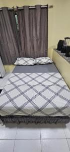 ein Bett in einem Zimmer mit einem Fenster in der Unterkunft Meu lugar! in Manaus